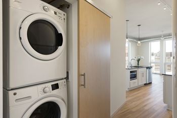 A white washing machine and dryer stacked on top of each other in a kitchen.